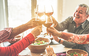 a family toasts glasses of wine at a dinner event